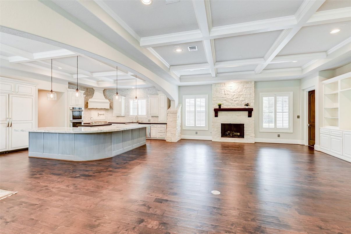 Empty room, Fireplace, Interior, Kitchen, Pendant Lights, Recessed Lighting, Stainless Steel Appliances, Wood Texture Flooring