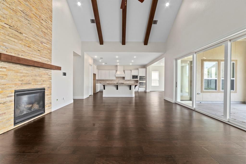 Empty room, Fireplace, Interior, Kitchen, Recessed Lighting, Stainless Steel Appliances, Stone Walls, Wooden Beams, Wood Texture Flooring