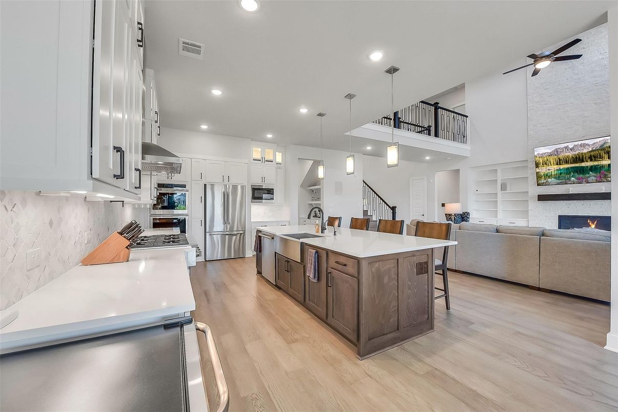 Fireplace, Interior, Kitchen, Living room, Pendant Lights, Recessed Lighting, Stainless Steel Appliances, Wood Texture Flooring