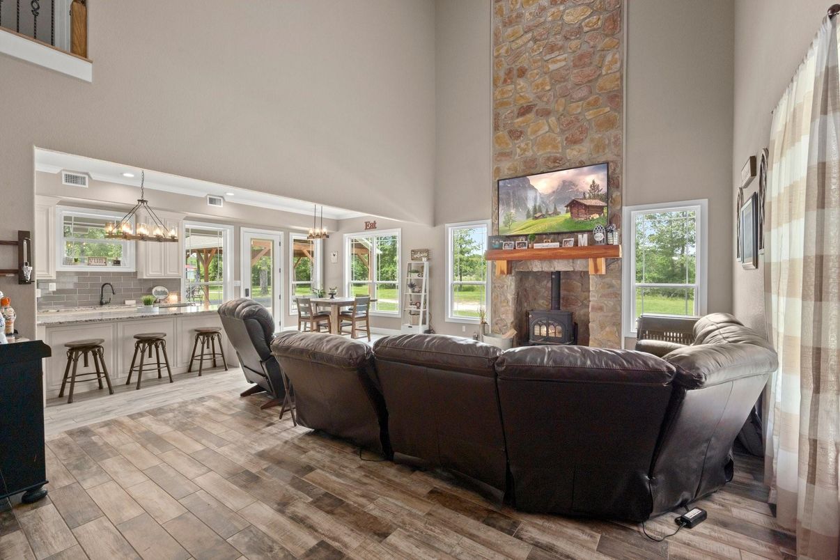 Chandelier, Dining room, Fireplace, Interior, Living room, Pendant Lights, Stone Walls, Wood Texture Flooring