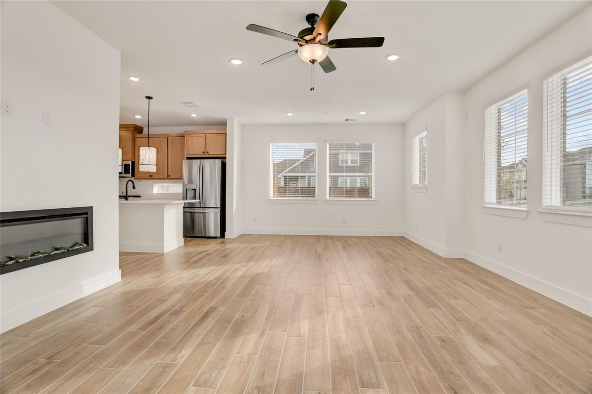 Empty room, Fireplace, Interior, Kitchen, Pendant Lights, Recessed Lighting, Stainless Steel Appliances, Wood Texture Flooring