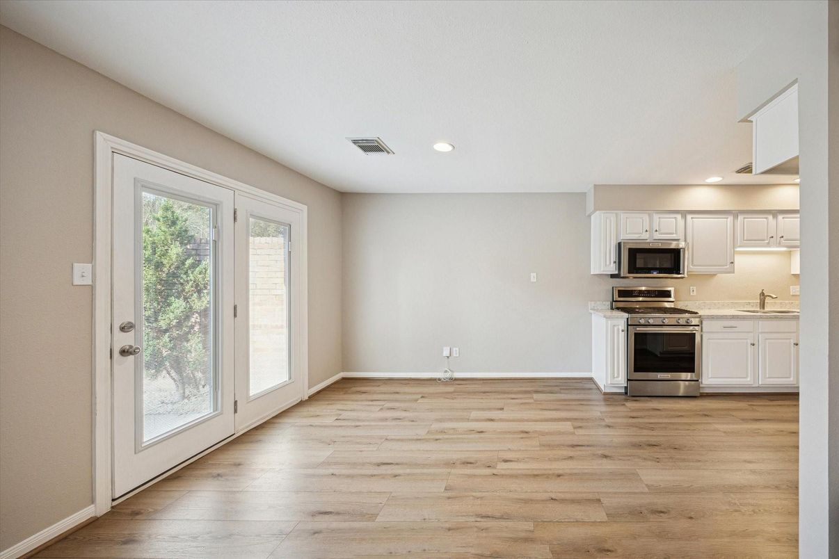 Empty room, Interior, Kitchen, Recessed Lighting, Stainless Steel Appliances, Wood Texture Flooring