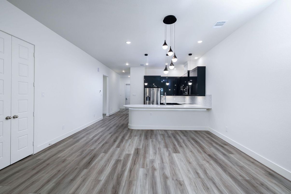 Empty room, Interior, Kitchen, Pendant Lights, Recessed Lighting, Stainless Steel Appliances, Wood Texture Flooring
