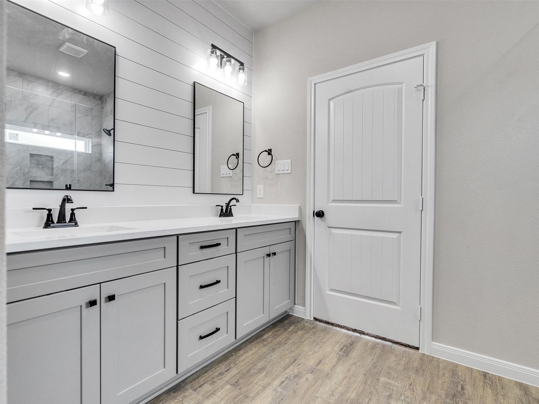 Bathroom, Dual Sink Vanities, Interior, Marble Walls, Recessed Lighting, Wood Texture Flooring
