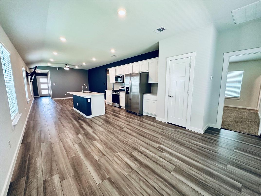 Empty room, Interior, Kitchen, Recessed Lighting, Stainless Steel Appliances, Wood Texture Flooring
