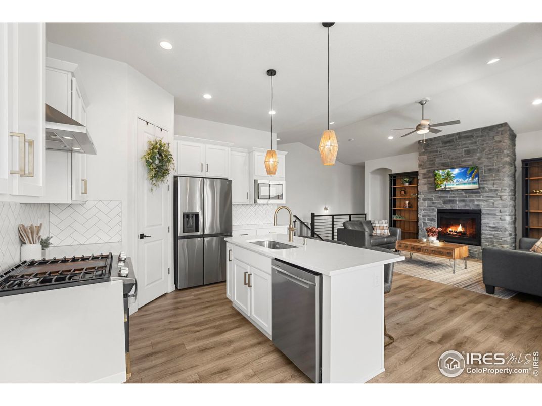 Fireplace, Interior, Kitchen, Living room, Pendant Lights, Recessed Lighting, Stainless Steel Appliances, Stone Walls, Wood Texture Flooring