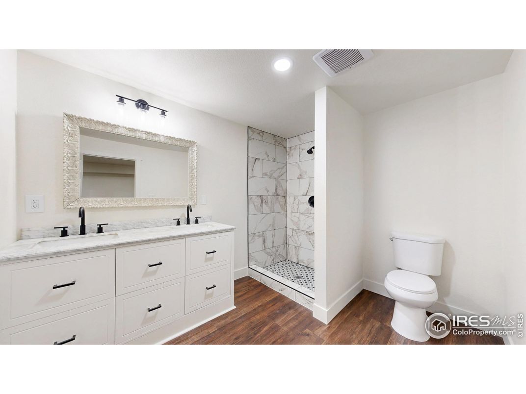 Bathroom, Dual Sink Vanities, Glass Shower, Interior, Marble Walls, Recessed Lighting, Wood Texture Flooring