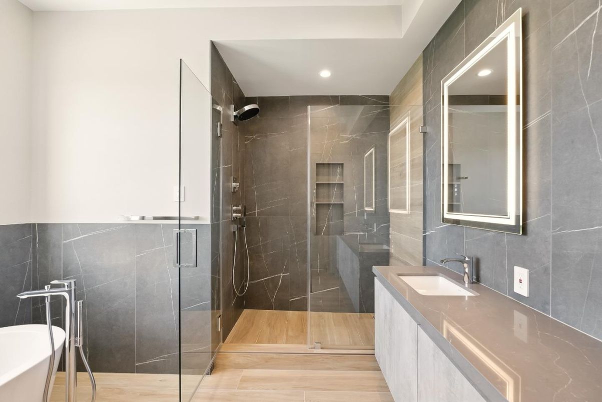 Bathroom, Dual Sink Vanities, Glass Shower, Interior, Marble Walls, Recessed Lighting, Wood Texture Flooring