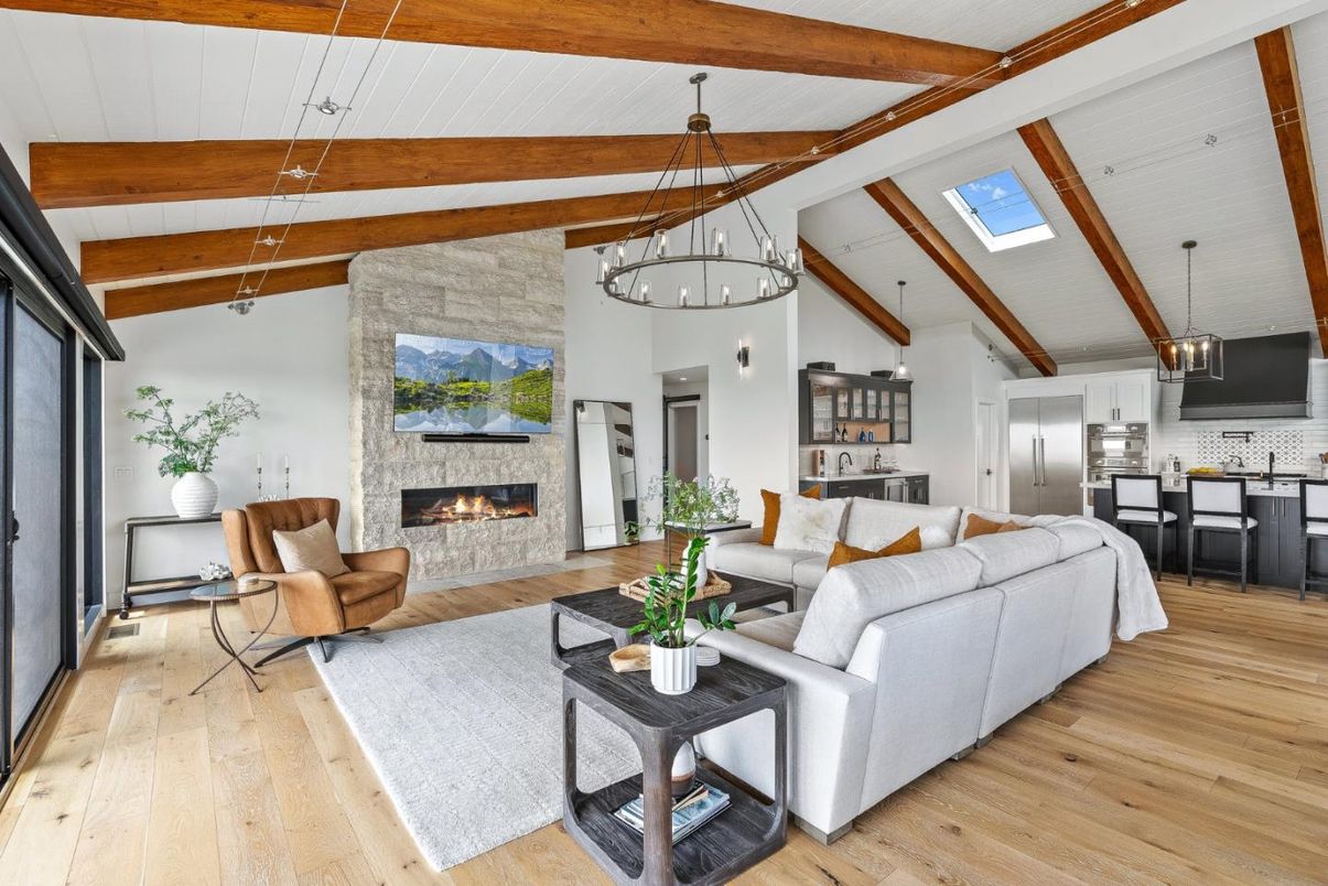 Chandelier, Fireplace, Interior, Kitchen, Living room, Pendant Lights, Stainless Steel Appliances, Stone Walls, Wooden Beams, Wood Texture Flooring