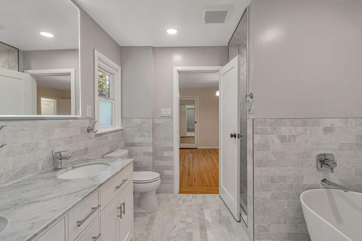 Bathroom, Dual Sink Vanities, Free Standing Baths, Interior, Marble, Recessed Lighting, Stone Walls, Wood Texture Flooring