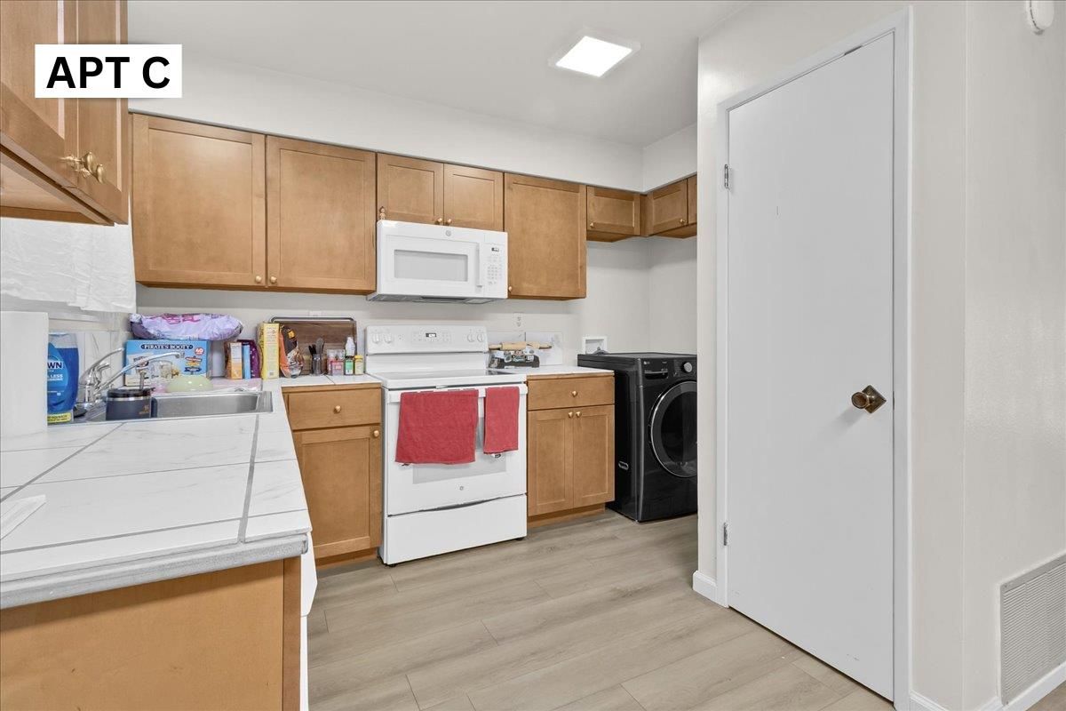 Interior, Kitchen, Recessed Lighting, Tile Countertops, Washer, Wood Texture Flooring
