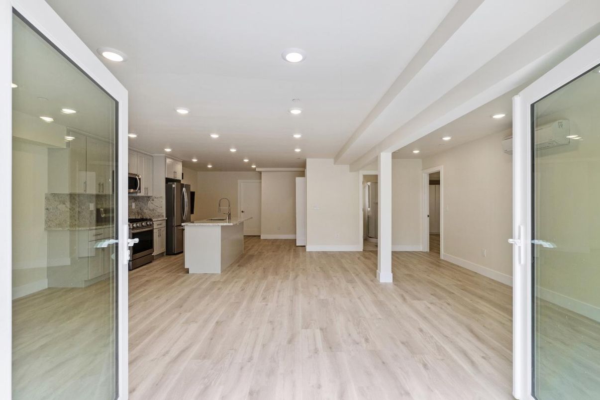 Empty room, Interior, Kitchen, Recessed Lighting, Stainless Steel Appliances, Wood Texture Flooring