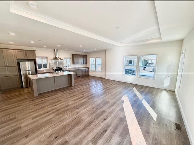 Empty room, Interior, Kitchen, Recessed Lighting, Stainless Steel Appliances, Wood Texture Flooring