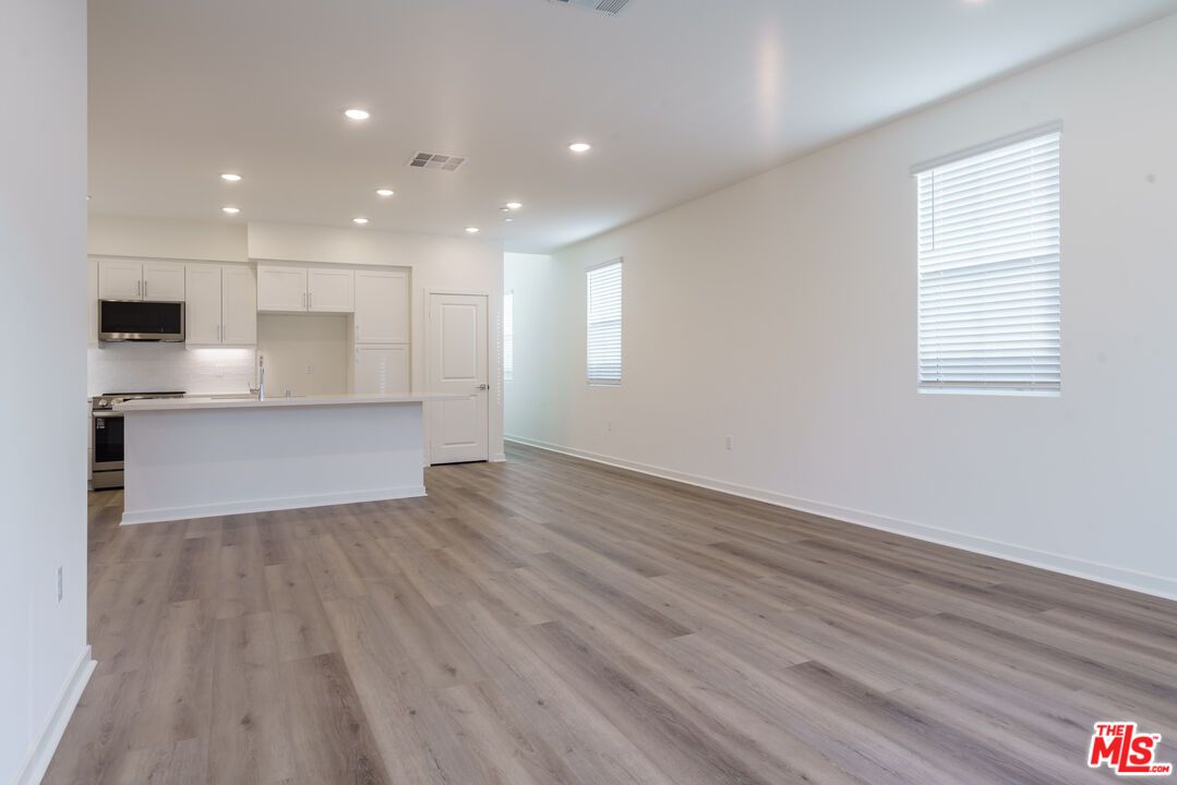 Empty room, Interior, Kitchen, Recessed Lighting, Stainless Steel Appliances, Wood Texture Flooring