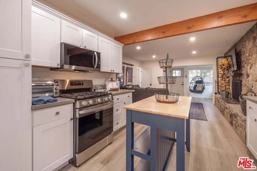 Fireplace, Interior, Kitchen, Pendant Lights, Recessed Lighting, Stainless Steel Appliances, Stone Walls, Wooden Beams, Wood Texture Flooring