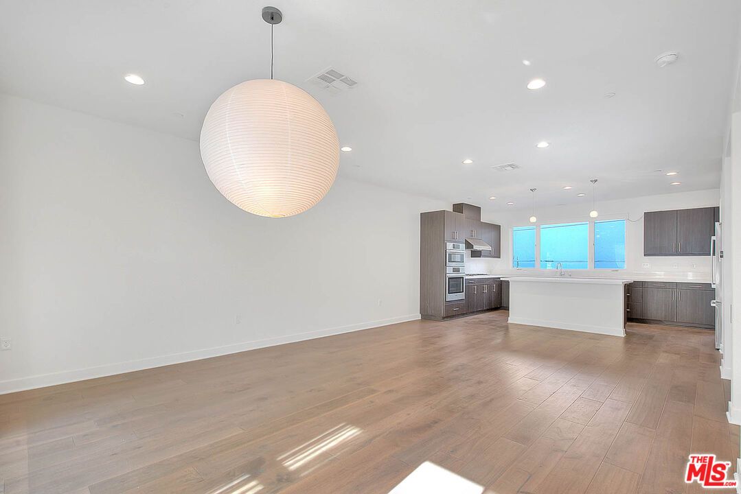 Empty room, Interior, Kitchen, Pendant Lights, Recessed Lighting, Stainless Steel Appliances, Wood Texture Flooring