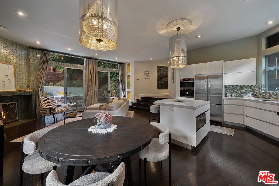 Chandelier, Dining room, Fireplace, Interior, Kitchen, Living room, Pendant Lights, Recessed Lighting, Stainless Steel Appliances, Wood Texture Flooring