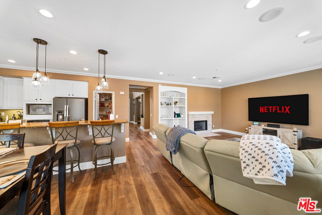 Fireplace, Interior, Kitchen, Living room, Pendant Lights, Recessed Lighting, Stainless Steel Appliances, Wood Texture Flooring