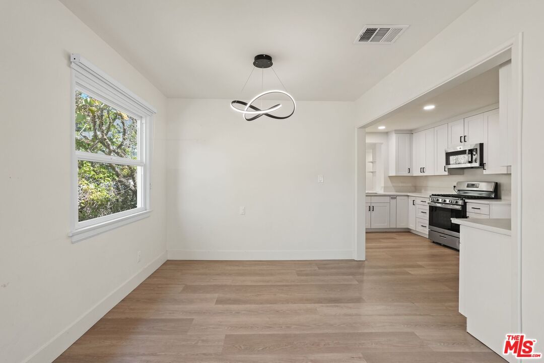 Empty room, Interior, Kitchen, Pendant Lights, Recessed Lighting, Stainless Steel Appliances, Wood Texture Flooring