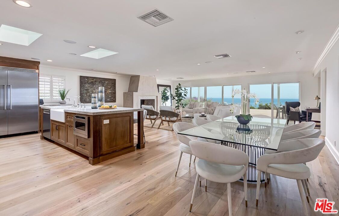 Dining room, Fireplace, Interior, Kitchen, Living room, Recessed Lighting, Stainless Steel Appliances, Water, Wood Texture Flooring