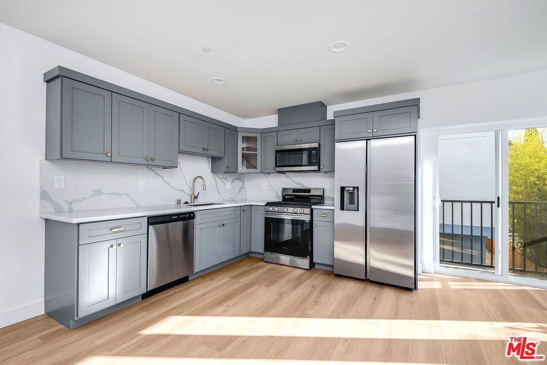 Interior, Kitchen, Marble Walls, Recessed Lighting, Stainless Steel Appliances, Wood Texture Flooring