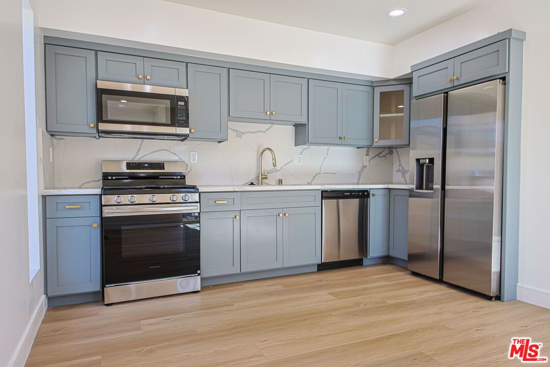 Interior, Kitchen, Marble Walls, Recessed Lighting, Stainless Steel Appliances, Wood Texture Flooring