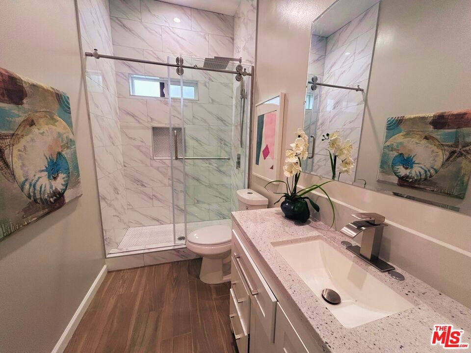 Bathroom, Dual Sink Vanities, Glass Shower, Interior, Marble Walls, Recessed Lighting, Wood Texture Flooring