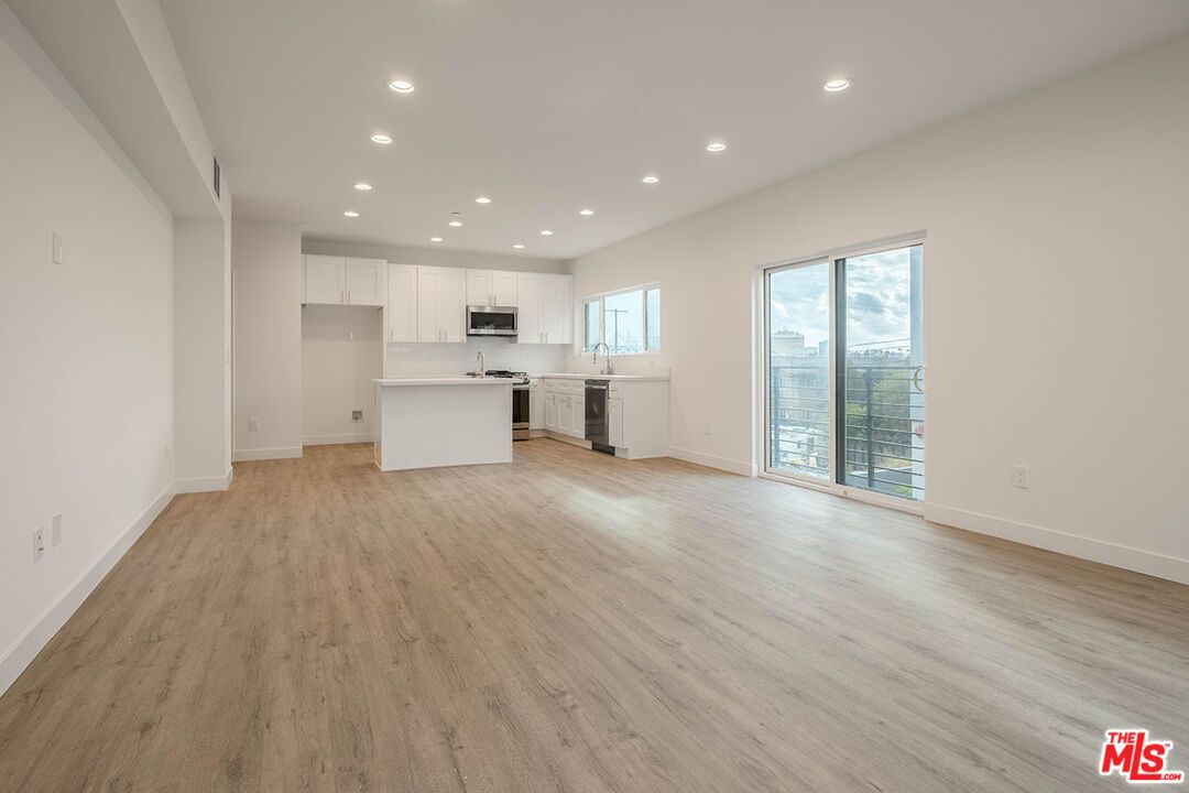 Empty room, Interior, Kitchen, Recessed Lighting, Stainless Steel Appliances, Wood Texture Flooring