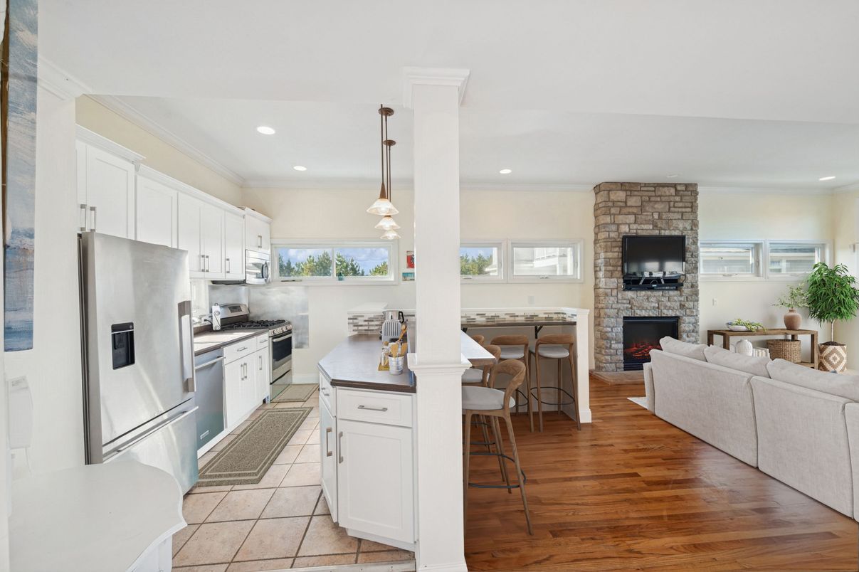 Fireplace, Interior, Kitchen, Living room, Pendant Lights, Recessed Lighting, Stainless Steel Appliances, Stone Walls, Wood Texture Flooring