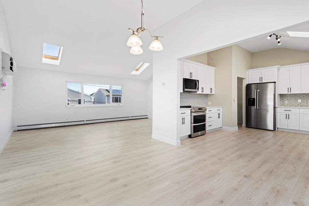 Empty room, Interior, Kitchen, Pendant Lights, Stainless Steel Appliances, Wood Texture Flooring