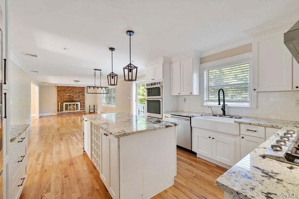 Fireplace, Interior, Kitchen, Pendant Lights, Recessed Lighting, Stainless Steel Appliances, Stone Walls, Wood Texture Flooring