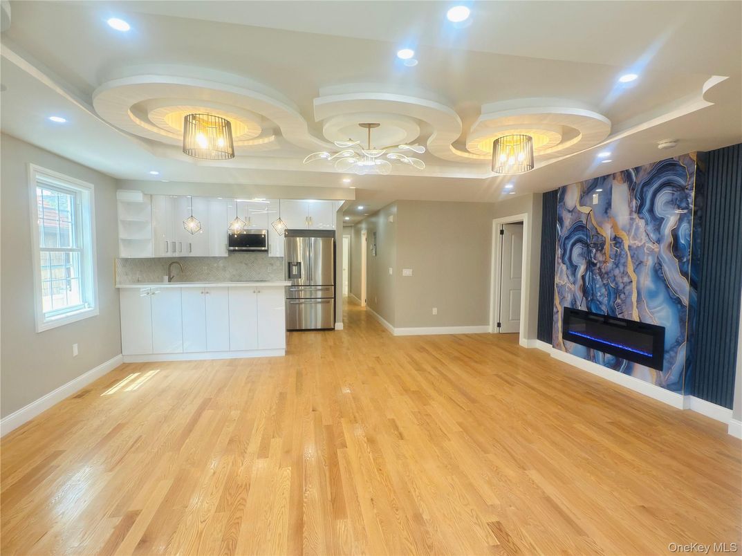 Empty room, Fireplace, Interior, Kitchen, Recessed Lighting, Stainless Steel Appliances, Wood Texture Flooring