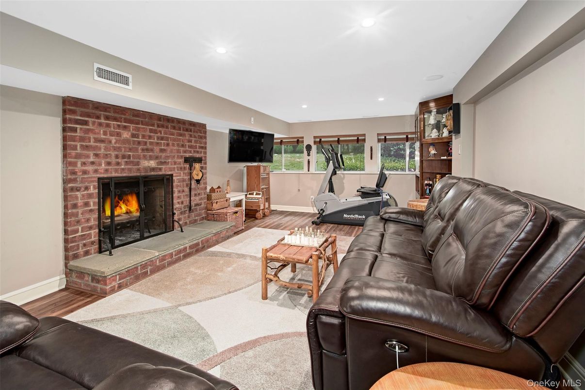 Fireplace, Fitness Equipment, Interior, Living room, Recessed Lighting, Stone Walls, Wood Texture Flooring