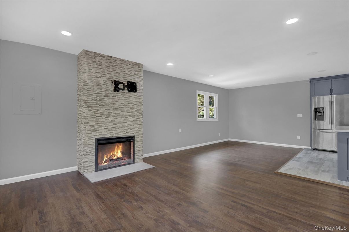 Empty room, Fireplace, Interior, Kitchen, Recessed Lighting, Stainless Steel Appliances, Wood Texture Flooring