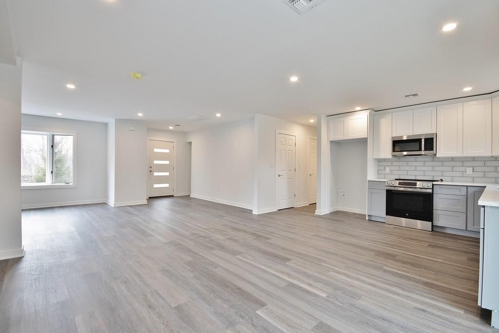 Empty room, Interior, Kitchen, Recessed Lighting, Stainless Steel Appliances, Wood Texture Flooring