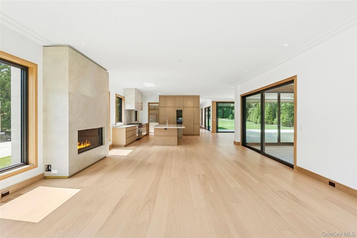 Empty room, Fireplace, Interior, Kitchen, Recessed Lighting, Stainless Steel Appliances, Wood Texture Flooring
