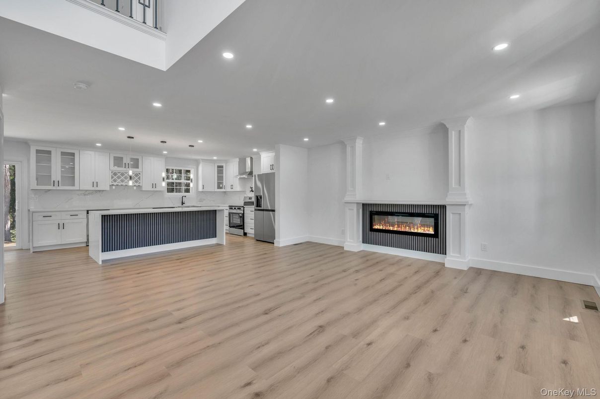 Empty room, Fireplace, Interior, Kitchen, Pendant Lights, Recessed Lighting, Stainless Steel Appliances, Wood Texture Flooring
