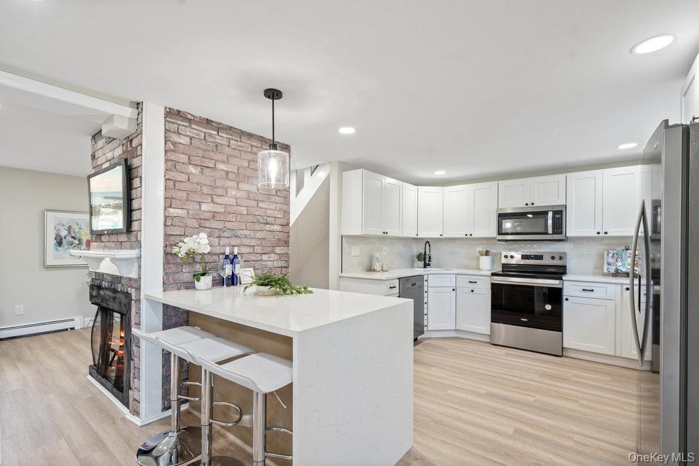 Fireplace, Interior, Kitchen, Pendant Lights, Recessed Lighting, Stainless Steel Appliances, Stone Walls, Wood Texture Flooring