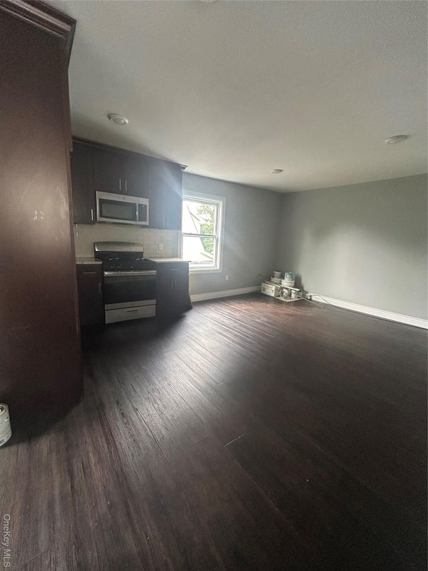 Empty room, Interior, Kitchen, Recessed Lighting, Stainless Steel Appliances, Wood Texture Flooring