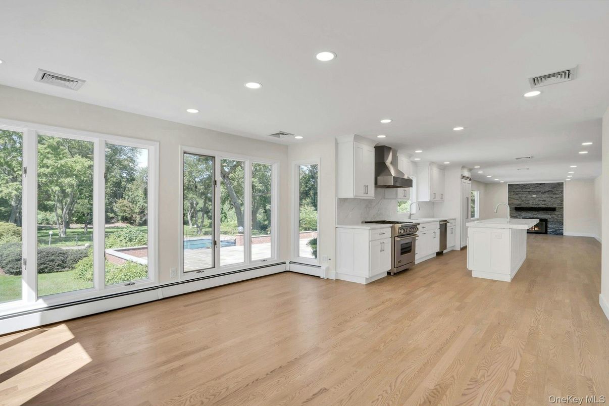 Empty room, Fireplace, Interior, Kitchen, Recessed Lighting, Stainless Steel Appliances, Wood Texture Flooring