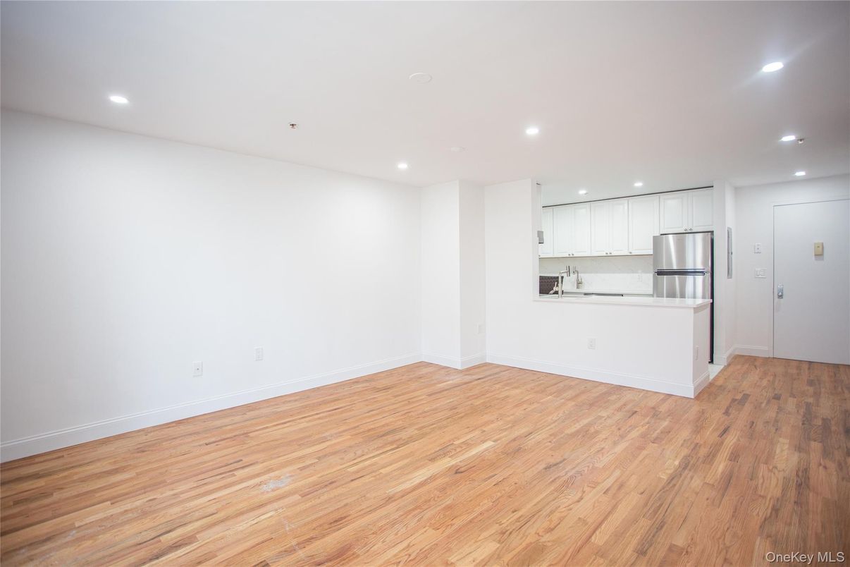 Empty room, Interior, Kitchen, Recessed Lighting, Stainless Steel Appliances, Wood Texture Flooring
