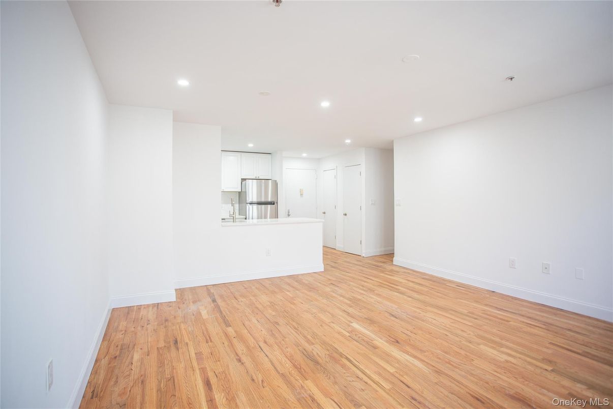 Empty room, Interior, Kitchen, Recessed Lighting, Stainless Steel Appliances, Wood Texture Flooring