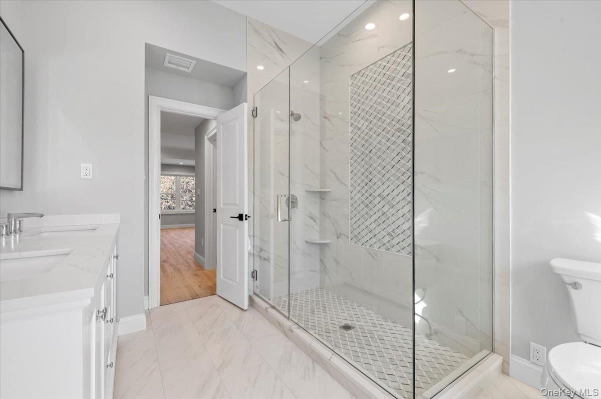 Bathroom, Dual Sink Vanities, Glass Shower, Interior, Marble, Marble Walls, Recessed Lighting, Wood Texture Flooring