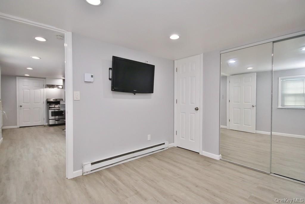 Empty room, Interior, Kitchen, Recessed Lighting, Stainless Steel Appliances, Wood Texture Flooring