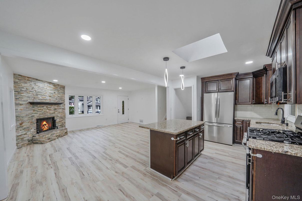 Fireplace, Interior, Kitchen, Pendant Lights, Recessed Lighting, Stainless Steel Appliances, Stone Walls, Wood Texture Flooring