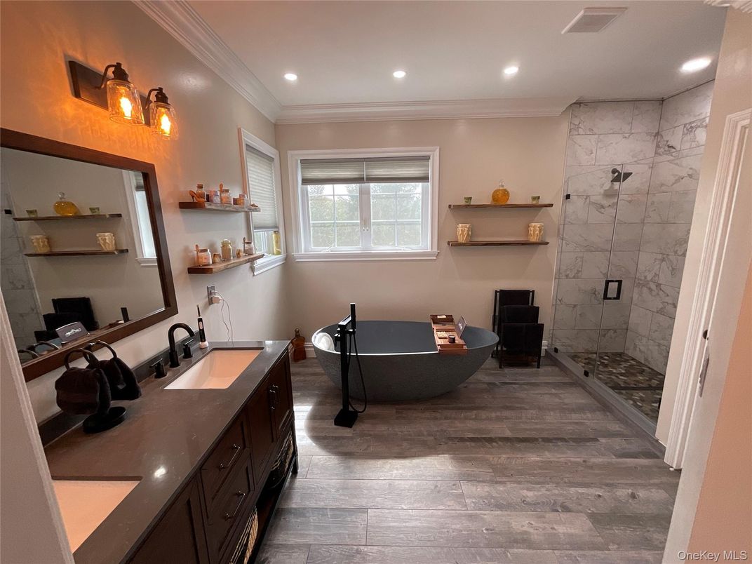 Bathroom, Dual Sink Vanities, Free Standing Baths, Glass Shower, Interior, Marble Walls, Recessed Lighting, Wood Texture Flooring