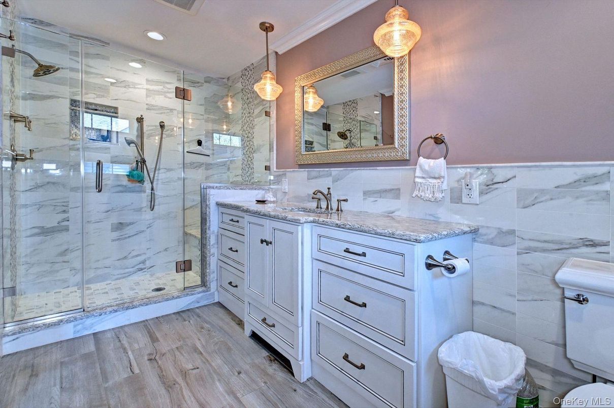 Bathroom, Dual Sink Vanities, Glass Shower, Interior, Marble Walls, Pendant Lights, Recessed Lighting, Wood Texture Flooring