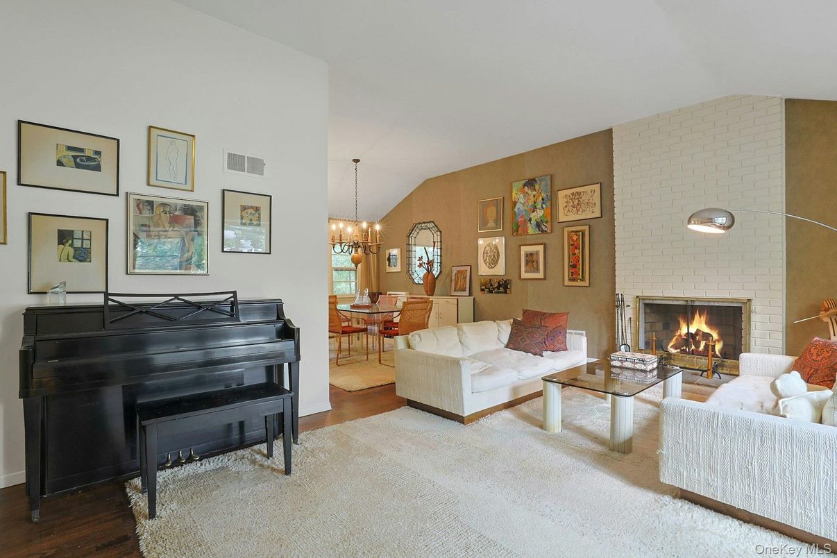 Chandelier, Dining room, Fireplace, Interior, Living room, Piano, Stone Walls, Wood Texture Flooring