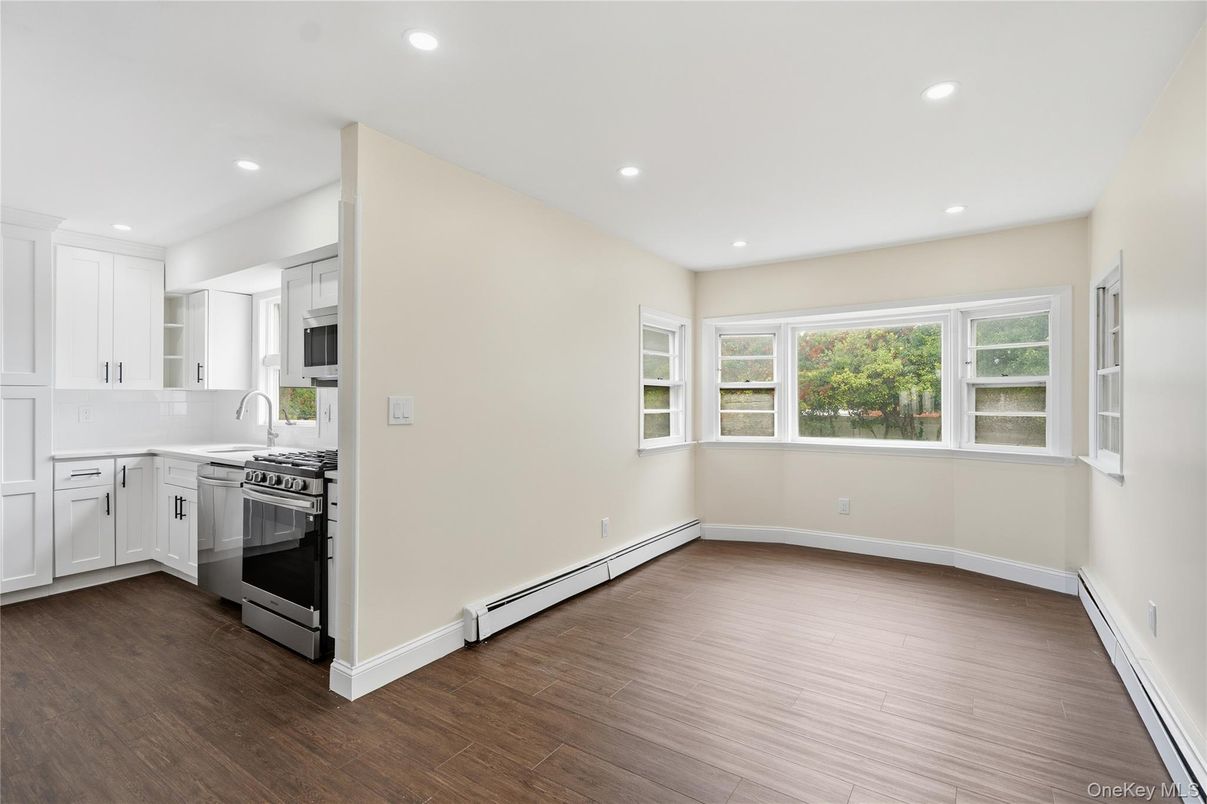 Empty room, Interior, Kitchen, Recessed Lighting, Stainless Steel Appliances, Wood Texture Flooring
