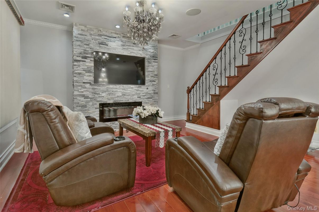 Chandelier, Fireplace, Interior, Living room, Recessed Lighting, Stone Walls, Wood Texture Flooring